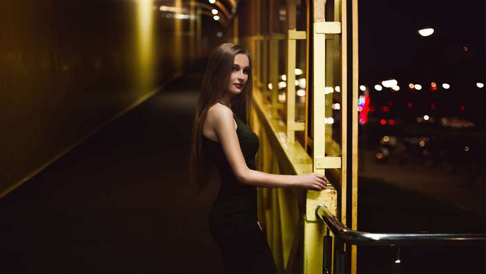 Woman posing on a pathway at night