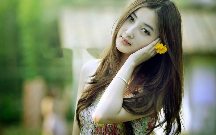 Young Asian woman with a yellow flower