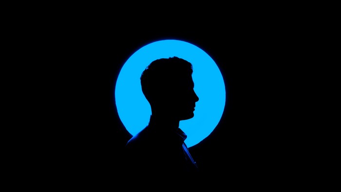 Silhouette of a man in front of a blue circle