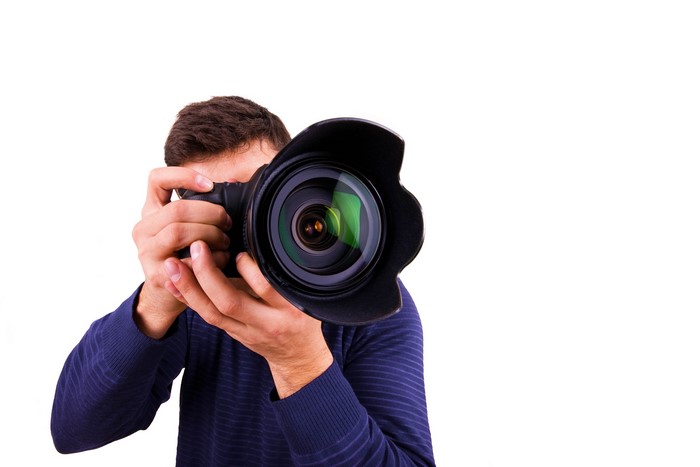 Man holding a professional camera with a large lens