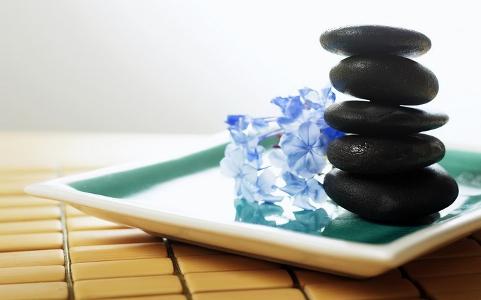 Stack of stones with blue flowers on a plate