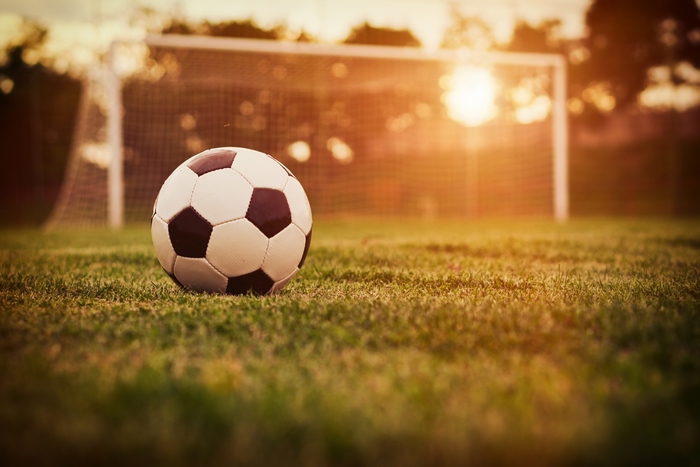 Soccer ball on a field at sunset