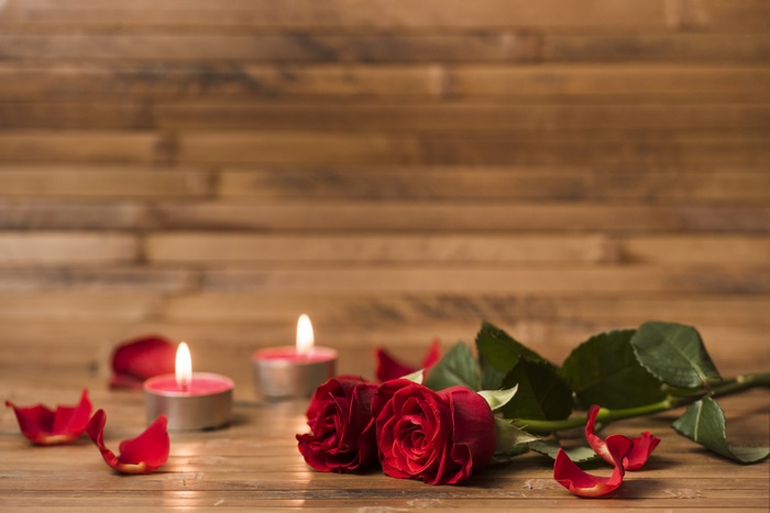 Romantic Red Roses with Lit Candles on Wooden Surface