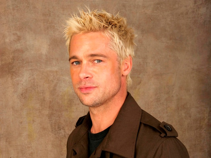 Brad Pitt with blonde spiky hair wearing a brown jacket