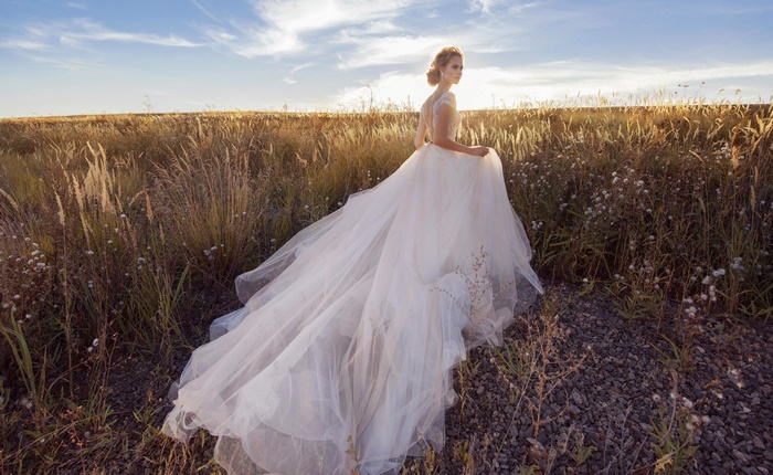 Bride in a white wedding dress in a field