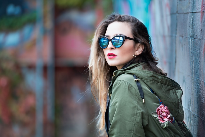 Woman wearing sunglasses and a green jacket