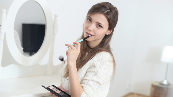 Mila Azul holding makeup brush and palette