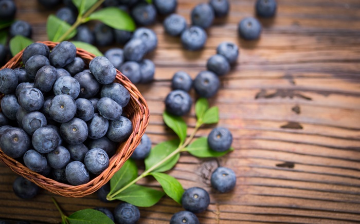 Blueberries in a basket on a wooden table