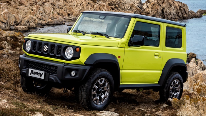 Yellow Suzuki Jimny parked on rocky terrain near water
