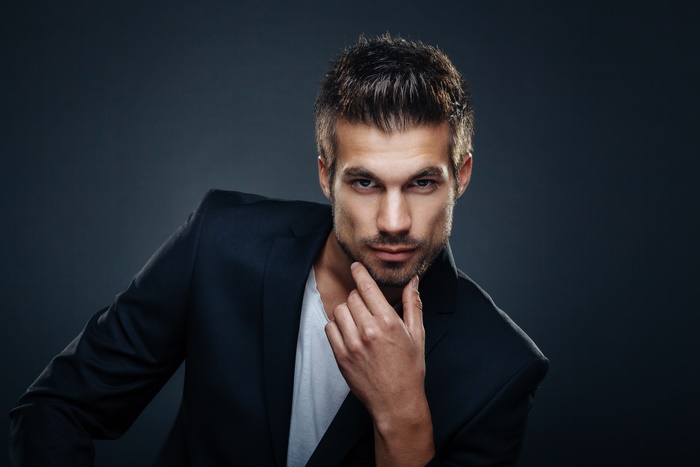 Man in a suit jacket with hand on chin
