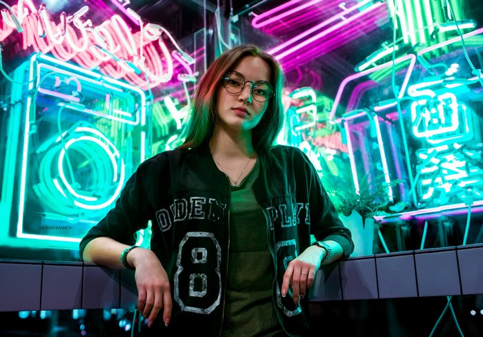Woman with glasses in front of neon lights