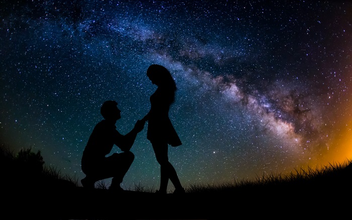 Couple silhouetted against the Milky Way