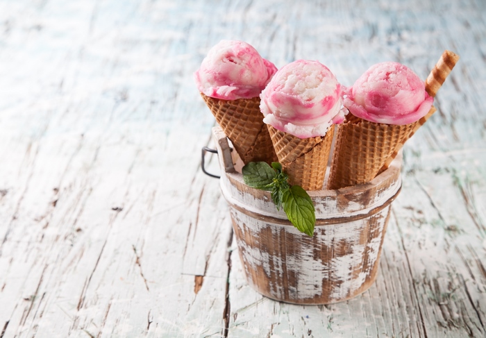 Three strawberry ice cream cones in a bucket