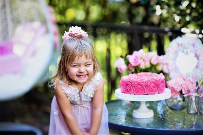 Little girl with pink cake and flowers