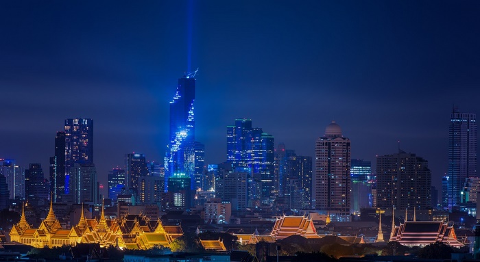 Bangkok cityscape at night with skyscrapers and temples