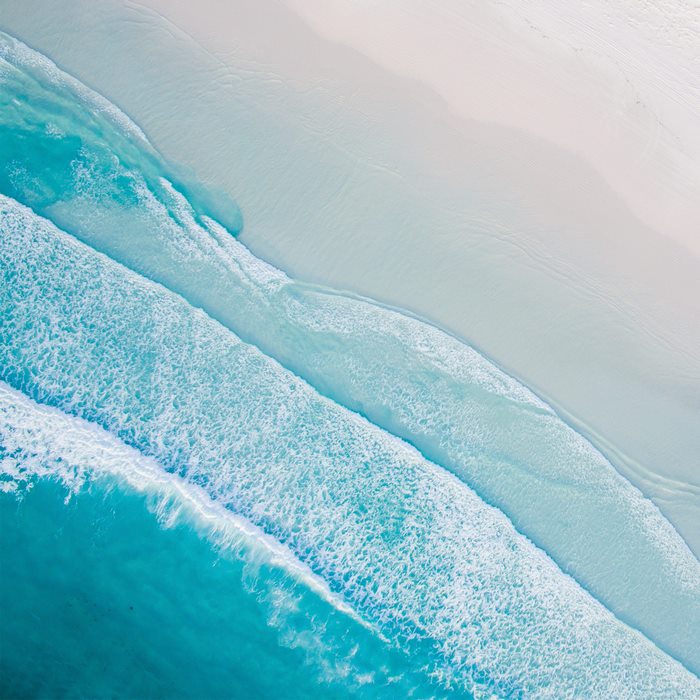Aerial view of ocean waves and sandy beach
