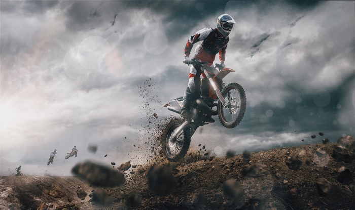 Motocross rider jumping over dirt track
