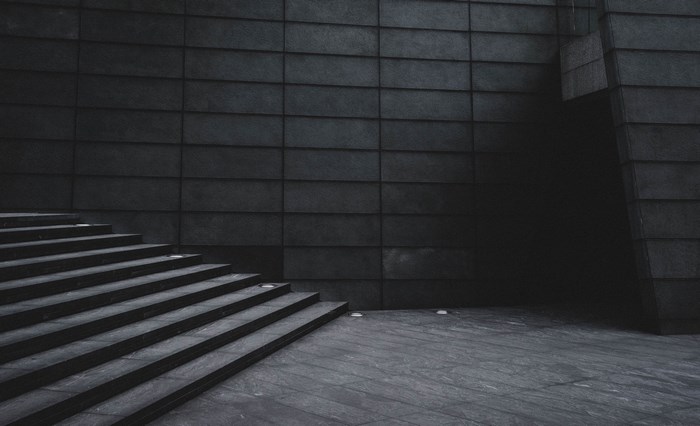 Dark concrete building with stairs and entrance