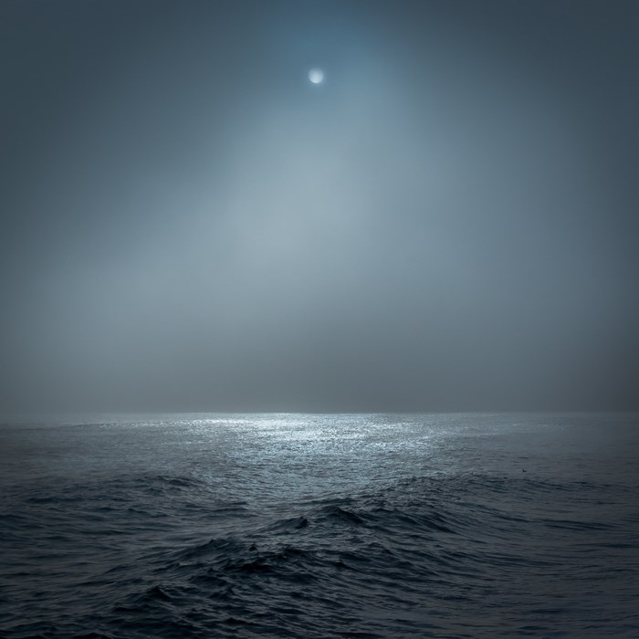 Misty ocean with moon reflection