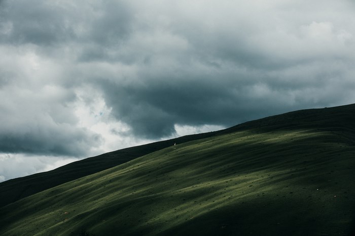 Green hills under cloudy sky