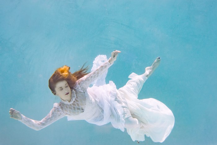 Woman in white dress underwater