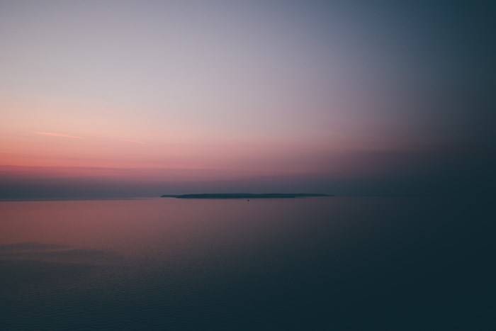Island in the ocean at sunset