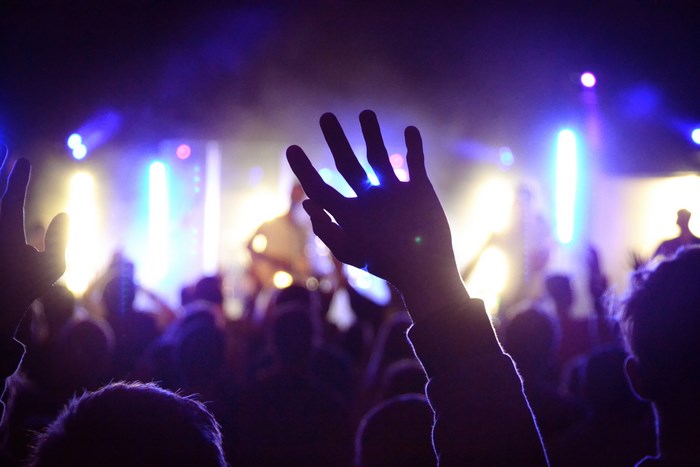 Concert crowd with hands raised in adoration