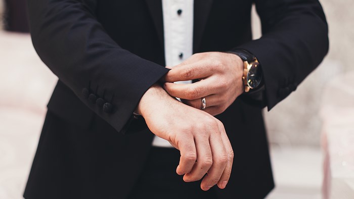Man in Tuxedo Adjusting Cuff with Watch and Ring