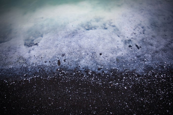 Black sand beach with foamy ocean waves
