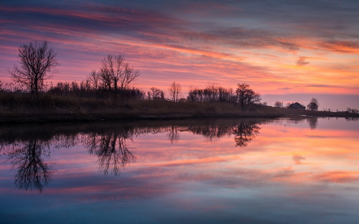 Sunset over a calm lake with reflections