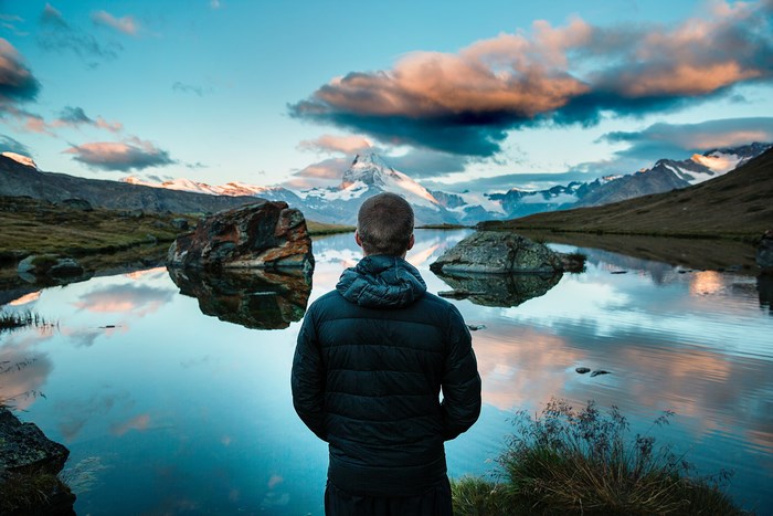 Man looking at Matterhorn mountain reflection in lake
