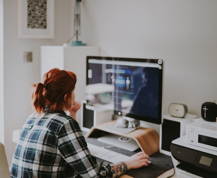 Woman with tattoos working on a computer at a desk