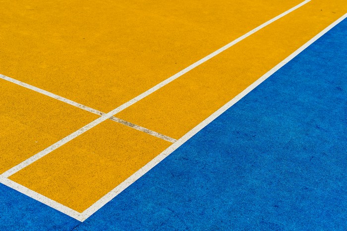 Close-up of a yellow and blue sports court with white lines
