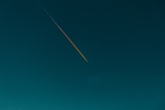 Airplane contrail in a dark blue sky