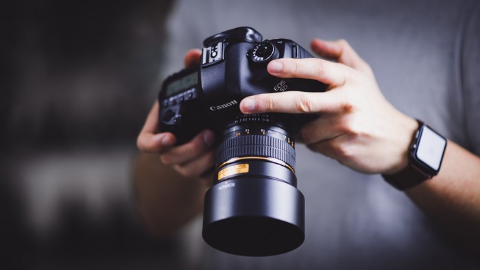 Canon EOS 5D camera held by hands with Apple Watch