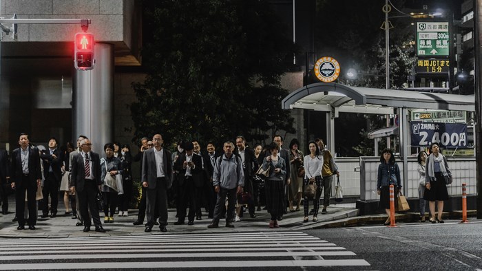 People waiting at a red light in Tokyo at night