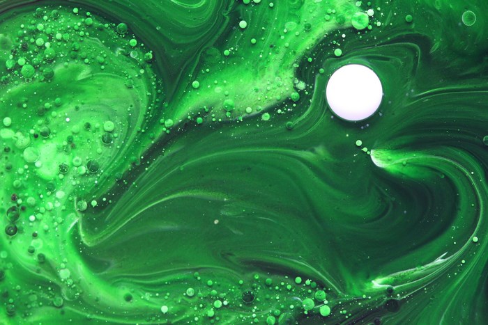 Green paint swirls with bubbles and a white circle