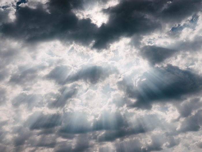 Sunbeams breaking through dark clouds