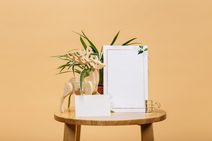 Wooden deer and plant on stool with cards