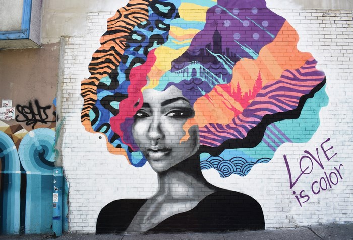 Mural of a woman with colorful abstract hair and "Love is color" text