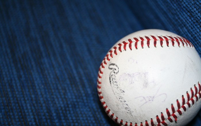 Autographed baseball on blue textured surface
