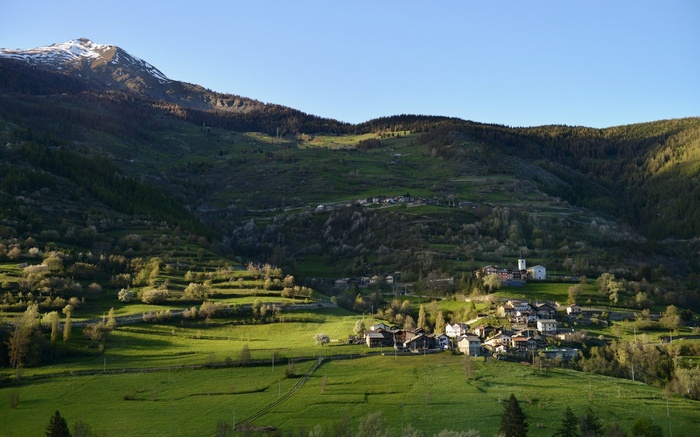 Mountain village with terraced fields and snow-capped peak