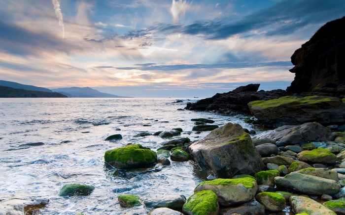 Rocky Shoreline with Moss-Covered Stones and Dramatic Sky