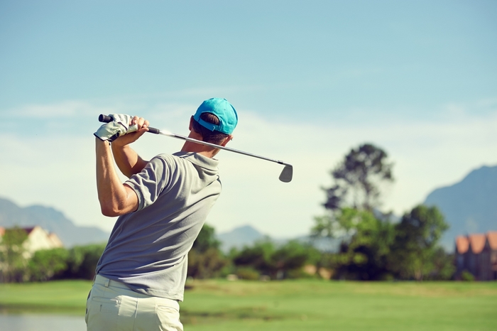 Golfer swinging a club on a golf course