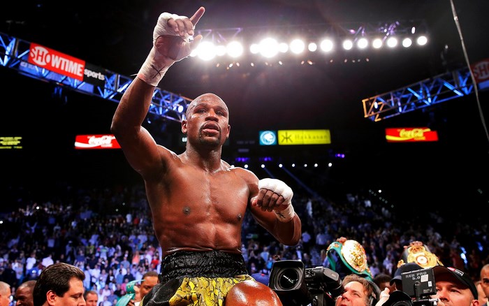 Floyd Mayweather Jr. in boxing ring with championship belts
