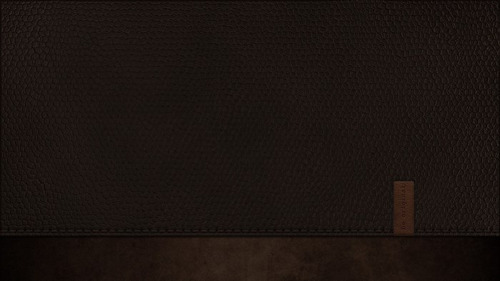 Dark brown leather texture with stitched seam and tag