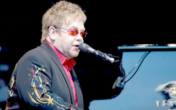 Elton John playing piano on stage