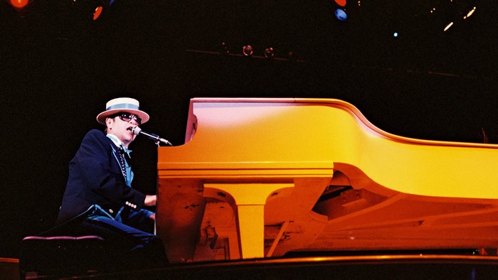 Elton John playing piano on stage