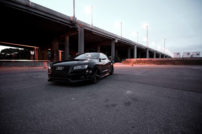 Black Audi RS5 parked under an overpass
