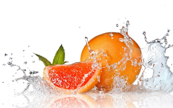 Grapefruit slice and whole grapefruit with water splash